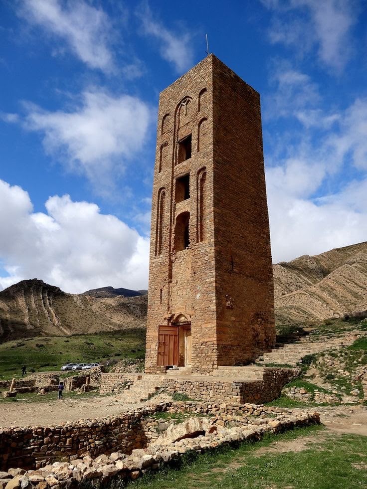 The Beni Hammad minaret above the excavated ruins, hills behind