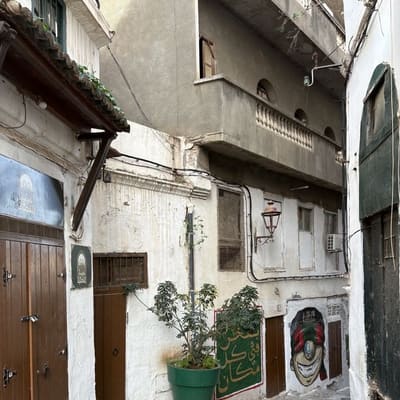 A quiet cobbled lane of whitewashed houses and wooden doors in the Casbah of Algiers