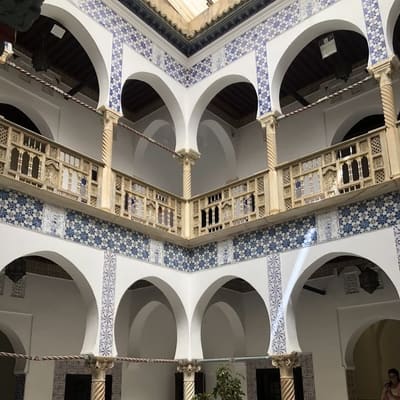 Horseshoe arches and blue-and-white tilework around an Ottoman palace courtyard in the Casbah