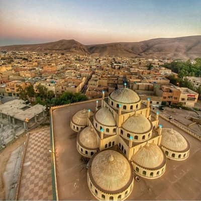 A many-domed mosque above the rooftops of Bou Saâda