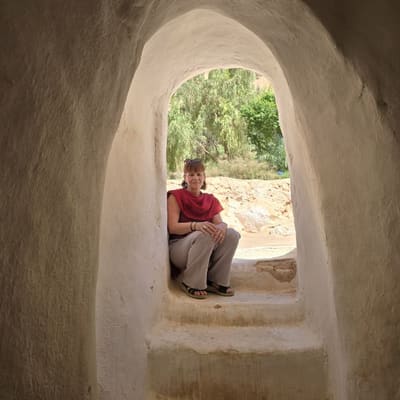 A traveller resting in the hand-moulded arched doorway of the Sidi Brahim mausoleum at El Atteuf