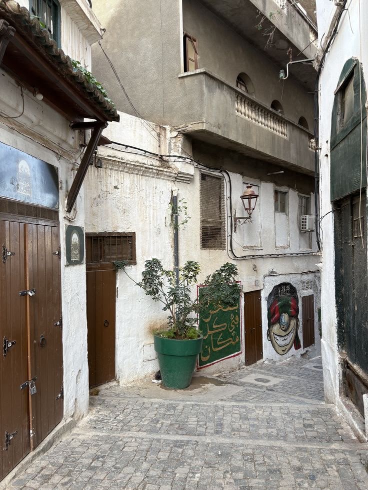 A quiet cobbled lane of whitewashed houses and wooden doors in the Casbah of Algiers