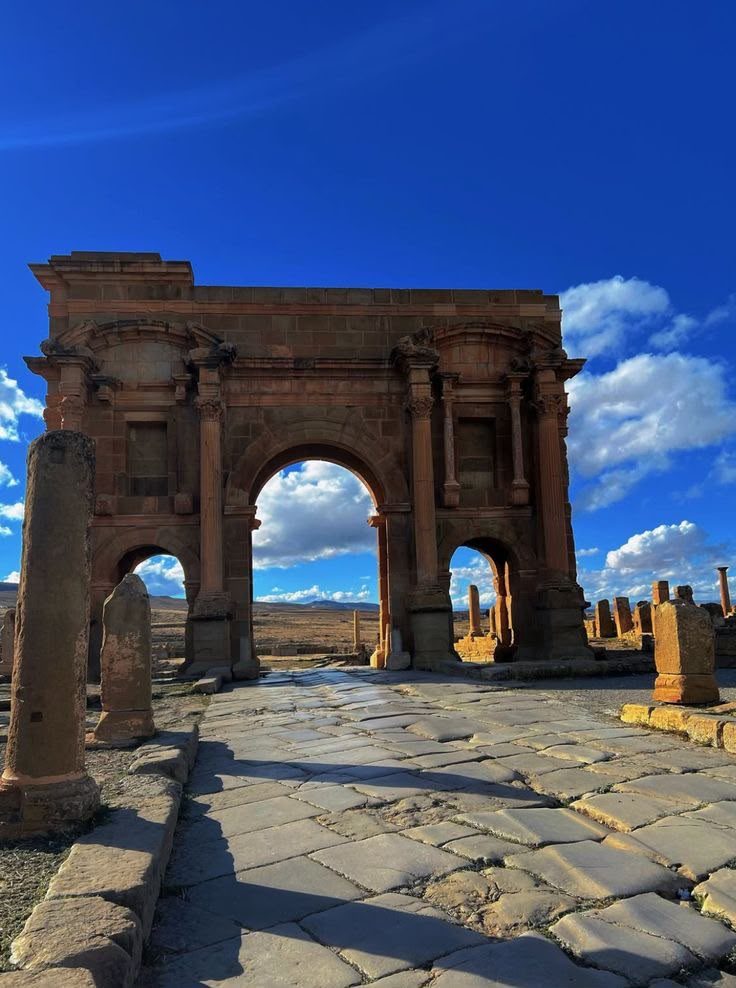 The Arch of Trajan seen from the paved main street of Timgad, its flagstones still rutted by cart wheels